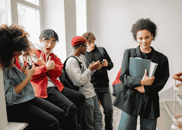 Teenage girl in school holding books smiling after support with mental health in the classroom