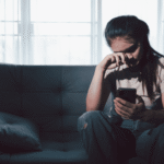 Teenage girl looking at phone needing support with ways to cope with global events