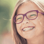 Teenage girl smiling outside in the sunshine after support with how to protect youth mental health