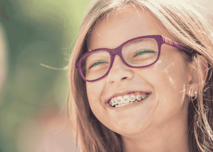Teenage girl smiling outside in the sunshine after support with how to protect youth mental health