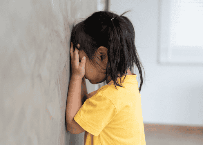 Young child hiding demonstrating how childhood trauma shapes the brain
