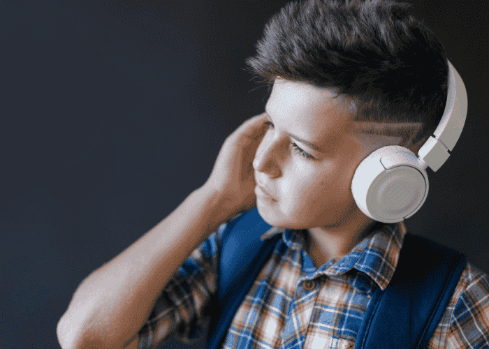 Teenage boy with ear defenders due to autism and trauma in teens