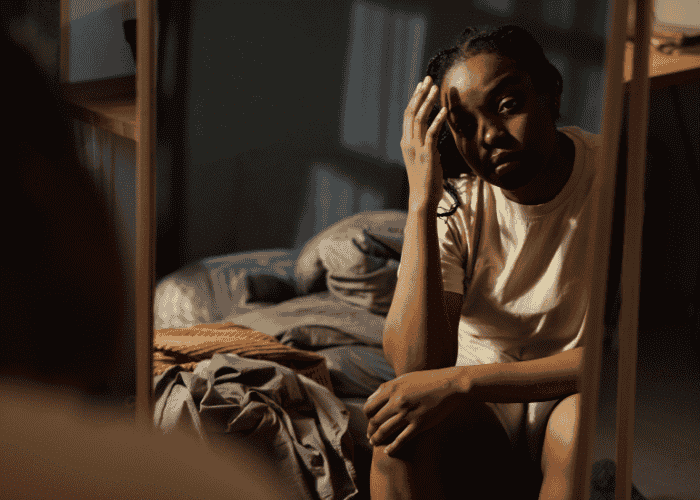 Teenager sitting in front of a mirror struggling due to sleep problems and adhd symptoms