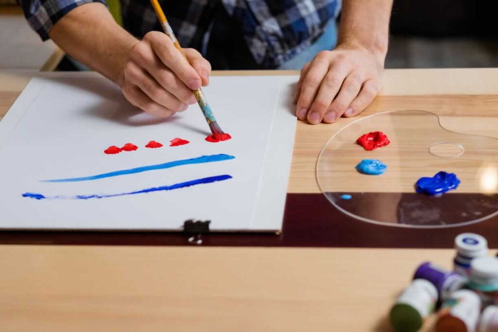 Person painting with blue and red paint colors