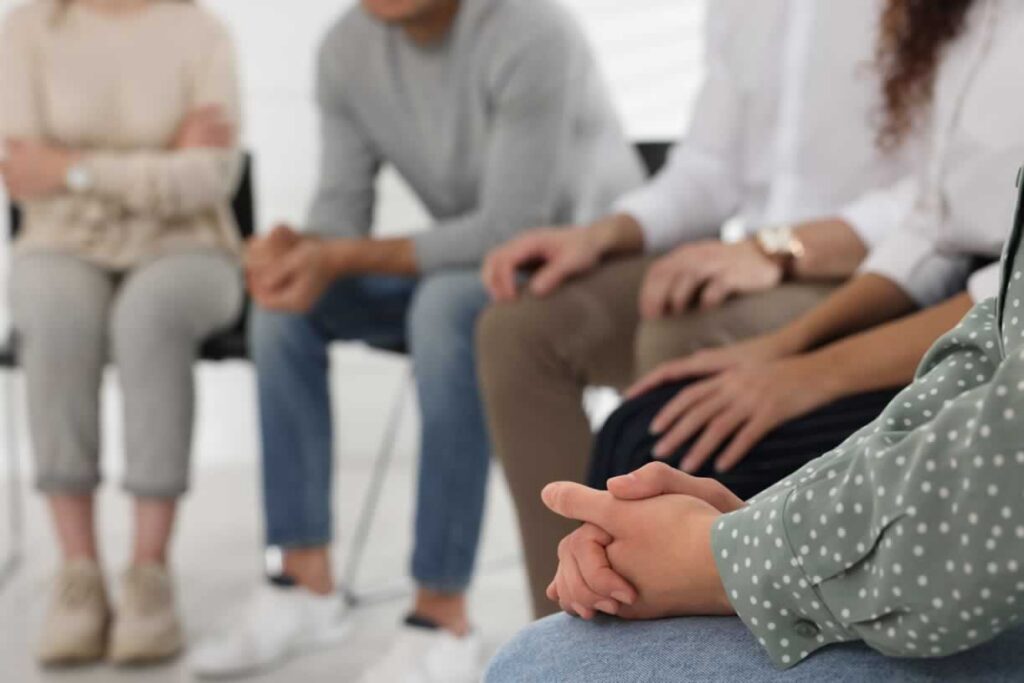 Group of teens sitting in chairs in a circle during group therapy