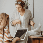 Mom angry at teen daughter sitting with feet on the table needing support with parent-teen conflict