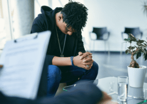 Teen boy sitting on sofa accessing therapy session after support with new laws in Virginia