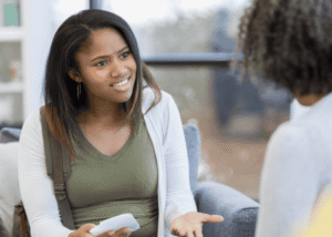 Mom sitting opposite angry teen daughter needing support with parenting style