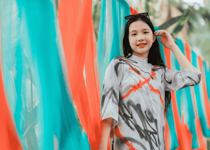 Teen girl outside standing by wall smiling after receiving support for rejection sensitive dysphoria