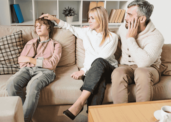 Parents sitting with teen on couch wondering how parents know it’s time for residential care