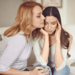 Mom with teen daughter on couch experiencing parent guilt