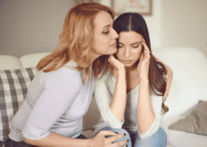 Mom with teen daughter on couch experiencing parent guilt