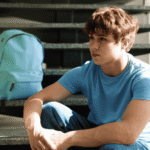 Teen boy sitting on step outside needing support with choosing the right residential program