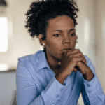 Mom sitting at table with chin resting on hands looking concerned about red flags when choosing programs
