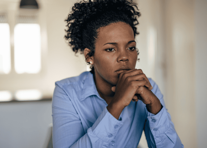 Mom sitting at table with chin resting on hands looking concerned about red flags when choosing programs
