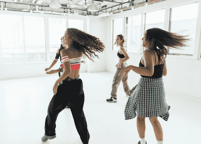 Teen girls dancing in dance studio after researching creativity and mental health
