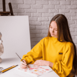 Teen girl drawing in art studio after researching link between creativity and mental health