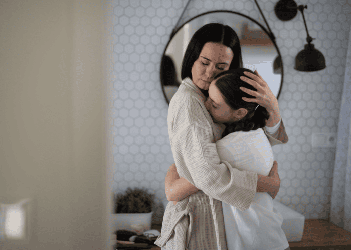 Mom hugging teen daughter needing support with what parents can expect emotionally