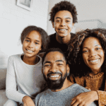 Parents sitting and smiling with their teenage children after support with what parents can expect emotionally.