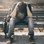 Teenager sitting on park bench needing support with teen navigating identity concerns.