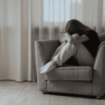 Sad girl sitting on a chair in need of residential mental health treatment programs for teens