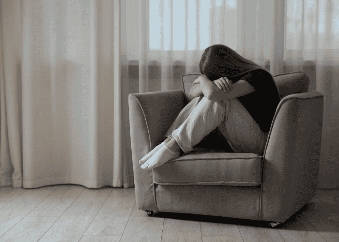 Sad girl sitting on a chair in need of mental health treatment programs