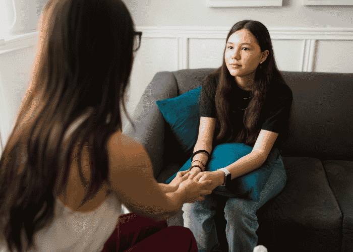 Mom holding daughters hands showing her family acceptance and LGBTQ+ teens listening