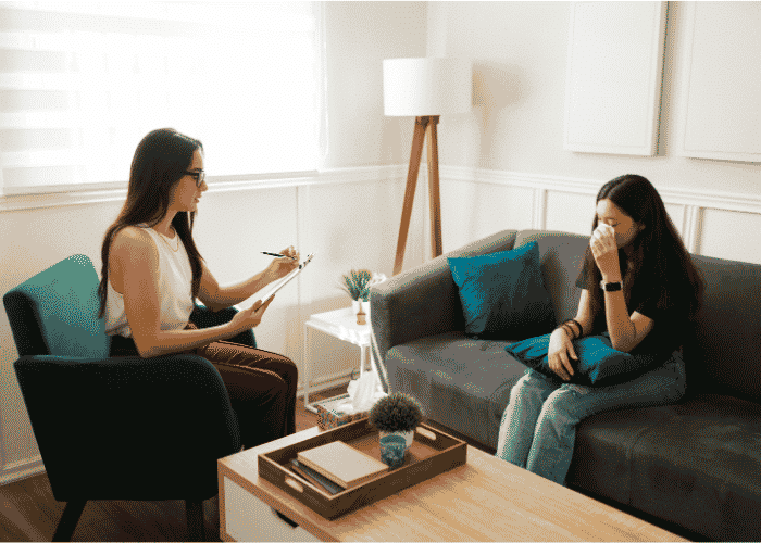 Teenage girl in therapy room talking about her identity after trauma