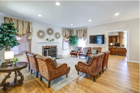 Mission Prep Healthcare residential group home with a warm, well-lit common area where teens gather for a structured group therapy session.