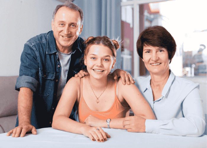 girl sitting down with family happy after reading information about out-of-network insurance