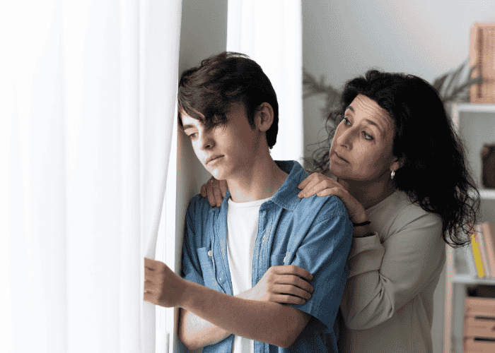 Teenage boy looking sad out of the window, in need of neurodiversity-affirming therapy for teens