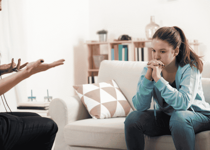 Teenage girl sitting during outpatient mental health treatment for teens