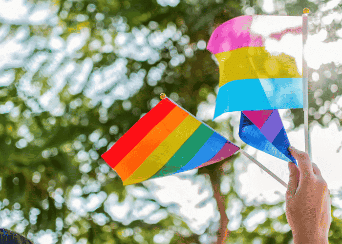 pride flags being waved by teens supporting sexual identity development in teens