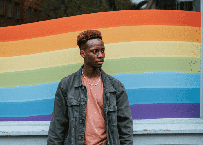 Teen boy standing outside needing support with school safety for LGBTQ+ teens
