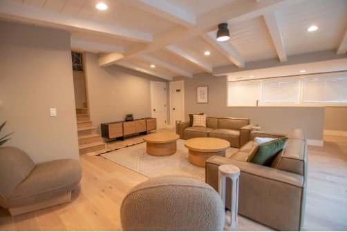 Warm, home-like living room at a Mission Prep teen residential facility, with soft sectionals and natural wood tones creating a calming treatment space.