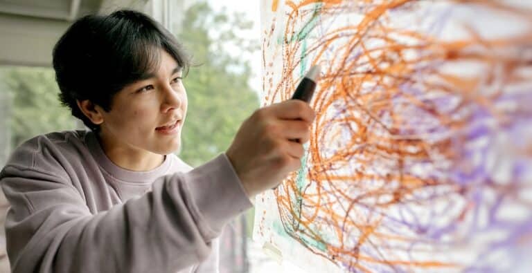 Teen boy drawing colorful picture for art project