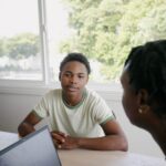 Teen boy sitting at table with therapist during counseling session