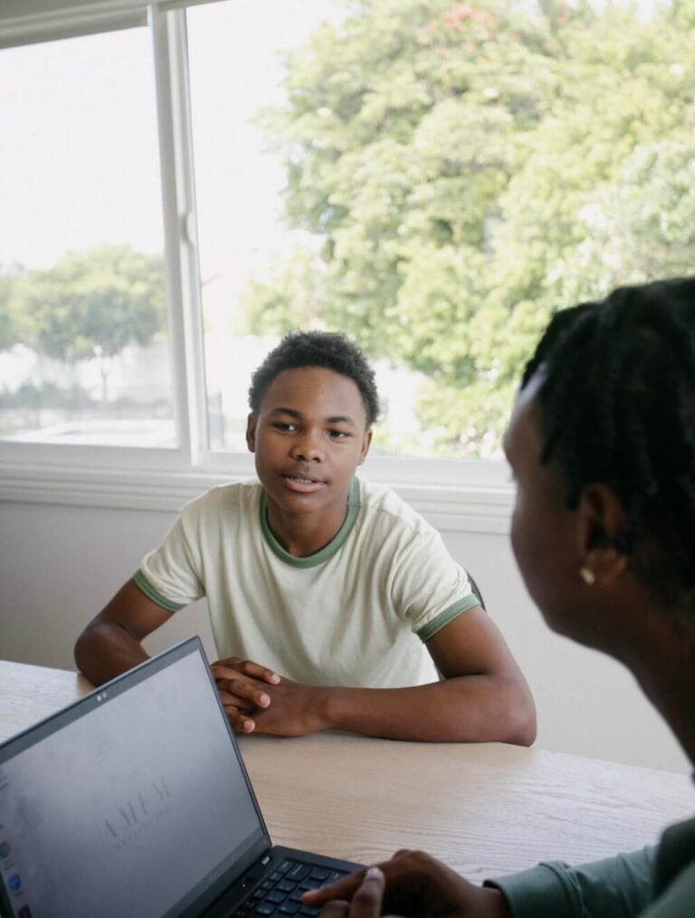 Teen boy sitting at table with therapist during counseling session