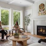Two women sitting in the living room at Mission Prep Teen Treatment Minnetonka Ella Lane next to large windows and a fireplace chatting