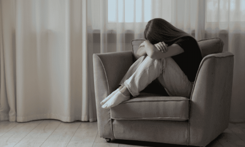 Sad girl sitting on a chair in need of mental health treatment programs